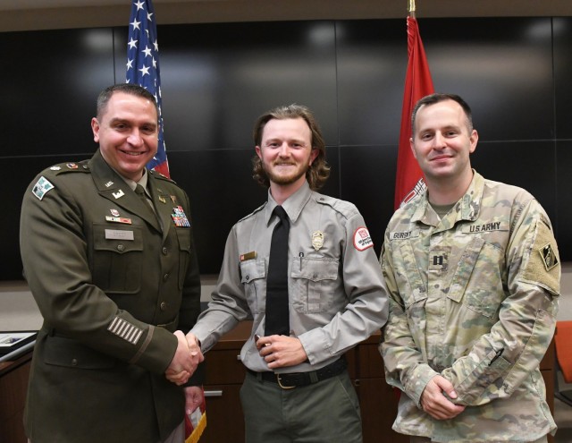 Lt. Col. Robert Green, U.S. Army Corps of Engineers Nashville District commander, left, presents a commander’s coin to Conservation Biologist Mitchell Crockarell of Cheatham Lake as Capt. Matthew Gursky, right, looks on May 5, 2025, in...