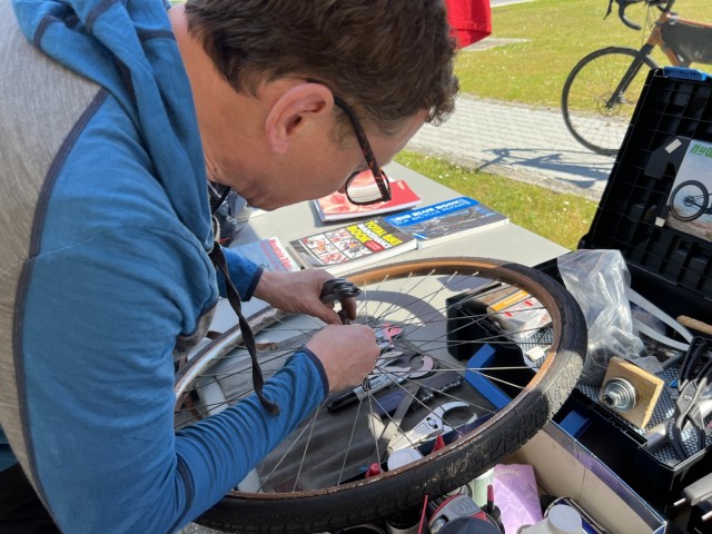 A Bike Week volunteer fixes a Darby Military Community member&#39;s bike tire.