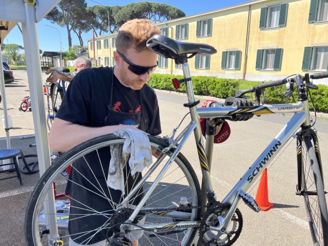 A volunteer fixes a DMC member&#39;s bicycle at Camp Darby Bike Week.