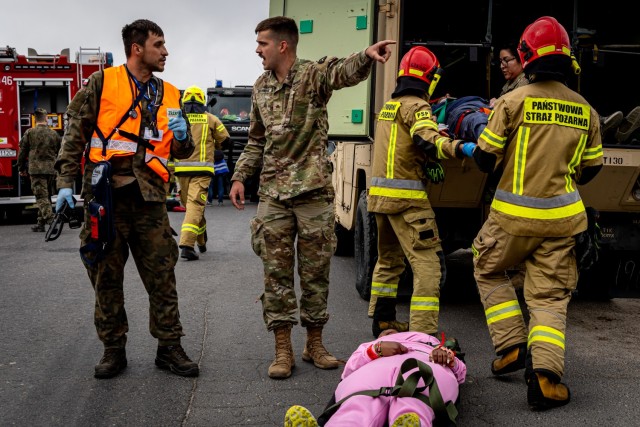 Polish Army Pvt. Piotr Maciejewski of the 33rd Air Base and U.S. Army Sgt. Christian Gochnour of the Texas Army National Guard’s 162nd Medical Company – Area Support treat a simulated casualty during a mass casualty exercise in Powidz, Poland,...