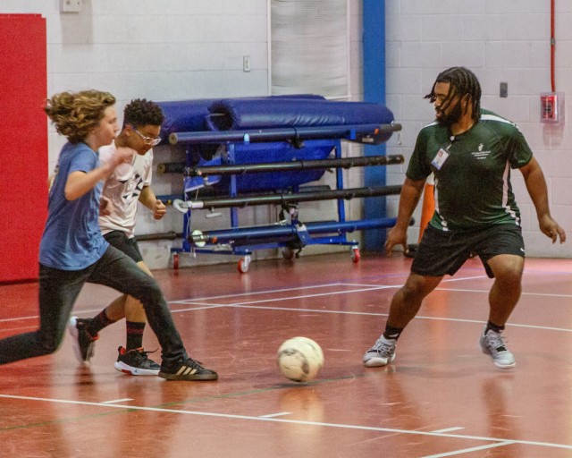 Isiah Robinson, Fort Belvoir Child Youth Program Assistant, right, challenges teens to a quick game of soccer at the Youth Center. Robinson, who attended the Center as a child back in 2004, now helps military teens stay fit and focused through a...