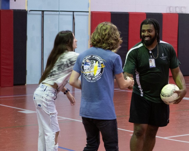 Isiah Robinson, Fort Belvoir Child Youth Program Assistant, right, congratulates teens after a game of soccer at the Youth Center. Robinson considers the Youth Center his 'second home,' having attended as a teen before becoming an...