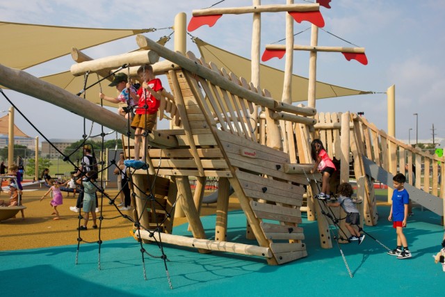 Los niños suben estructuras de madera, formadas como barcos con escaleras de cuerda y juegos de escaleras.