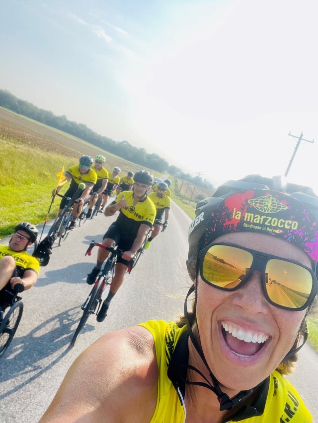 Image is a selfie of the recreational therapist from the accompanying article, that shows her cycling with Soldiers in recovery.