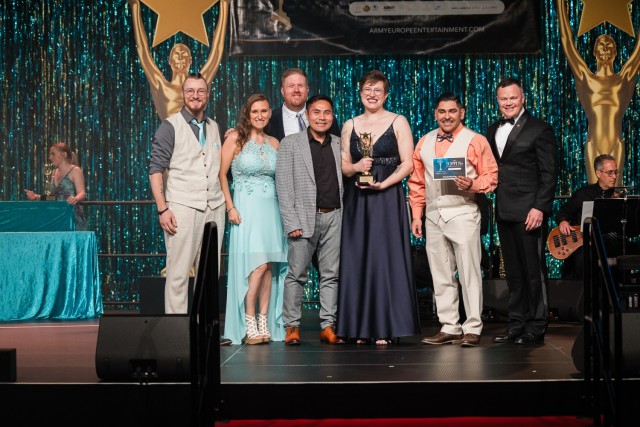 WIESBADEN, Germany -- Alyssa Brown, third from right, accepts the outstanding play award during the April 26, 2025 TOPPERs award at U.S. Army Garrison Wiesbaden. Her team won the award for the play &#34;Orphans.&#34; Tommy Mize, right, director of...