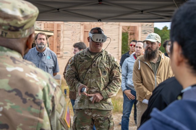 A Soldier uses an augmented reality-enabled capability amongst a group of stakeholders during the Army&#39;s Network Modernization Experiment 2024.