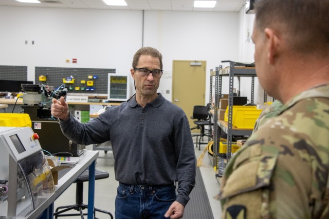 A man from the C5ISR Center's Prototype Integration Facility briefs a Soldier on the PIF's capabilities during a visit.