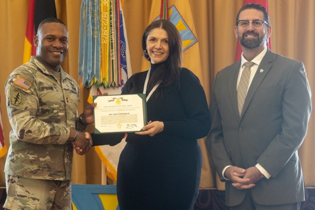 U.S. Army Maj. Gen. Ronald R. Ragin (left), the commanding general of the 21st Theater Sustainment Command, and Michael Amarosa (right), the Executive Civilian Deputy to the Commanding General, award Heike Hartgrove (center), a Department of Army...