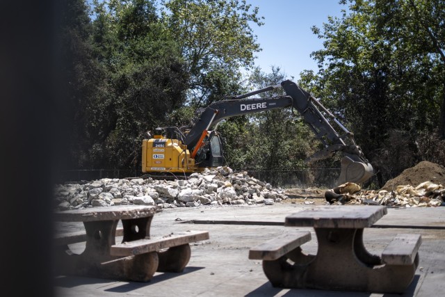 A contractor uses an excavator to remove concrete debris at the Native Plant Garden at Eaton Canyon Nature Center in Altadena, California, May 23, 2025. The effort is part of a broader wildfire recove