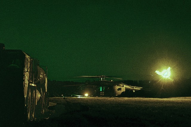 A M978 Heavy Expanded Mobility Tactical Truck is positioned at a forward arming and refueling point as HH-60M medevac helicopters prepare in the background during night operations at Preston Range, Fort Eisenhower, May 19, 2025.