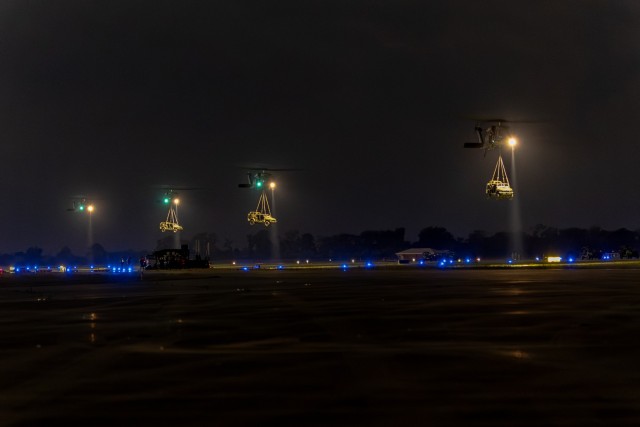 A line of UH-60 Blackhawk helicopters from the 82nd Combat Aviation Brigade, 82nd Airborne Division slingload Infantry Squad Vehicles from the 1st Mobile Brigade Combat Team, 101st Airborne Division (Air Assault) at the Alexandria, La. airport on...