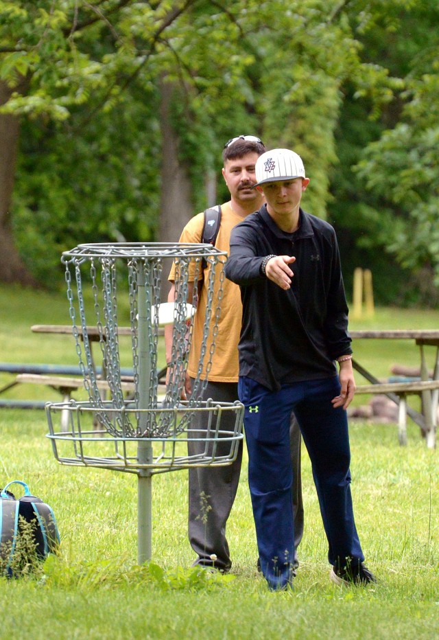 Father-and-son duo Team Dumb and Dumber Aaron and Ian Simmons play in the Strong B.A.N.D.S. Disc Golf Tournament May 24, 2025, at the Fort Leavenworth Disc Golf Course by Camp Conestoga at Fort Leavenworth, Kansas. Team Dumb and Dumber won the...