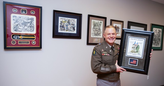 Col. Michael Solovey, assistant chief of staff, G4, U.S. Army Intelligence and Security Command, posing with the custom lithograph he created in honor of the Army's 250th birthday. The art was also used for a custom coin. The Soldiers in the...