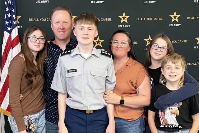 Christopher Johnson II, center, poses with his family after enlisting in the Army at an Army recruitment center.