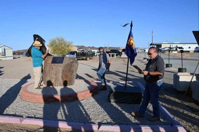 Retired Yuma Proving Ground Heritage Center curator Bill Heidner (left) unveils a modest plaque for the &#34;Spirit of Camp Laguna&#34; as Training Exercise Management Office personnel Kevin Hunt (center) and Luis Arroyo (right) look on. The...