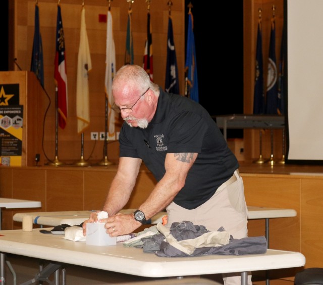 John Cantarella, an instructor with Achilles Strategic Readiness, demonstrates a medical procedure used to treat deep wounds called “wound packing” during the Civilian Active Attack Response Protocol training for the C5ISR workforce at the...
