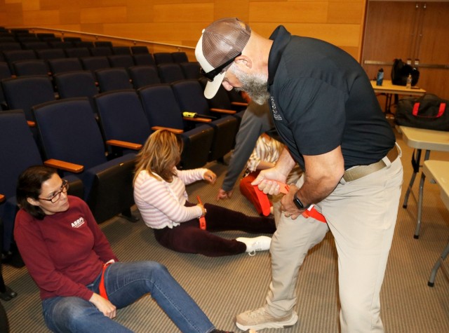 Tony Pisaro, an instructor with Achilles Strategic Readiness, shows Zamara Fuentes, with the U.S. Army Communications-Electronics Command Integrated Logistics Support Center, how to apply a tourniquet during the Civilian Active Attack Response...