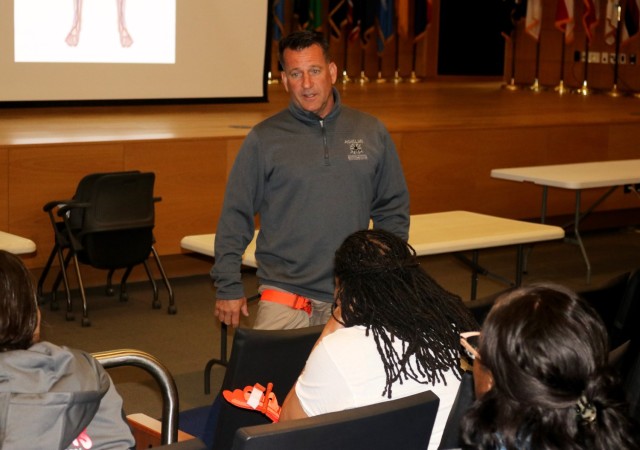Patrick Meffert, the CEO of Achilles Strategic Readiness, discusses learning how to apply a tourniquet during the Civilian Active Attack Response Protocol training for the C5ISR workforce at the Myer Auditorium May 20, 2025.