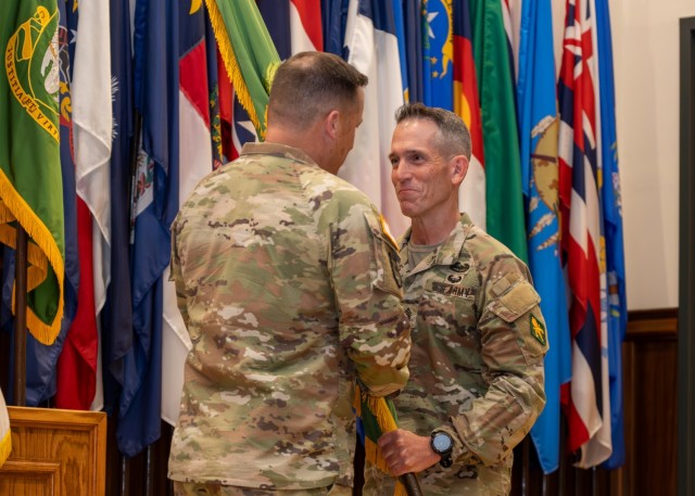 Outgoing U.S. Army Military Police School Command Sgt. Maj. William Shoaf passes the regiment’s flag to Col. Charles Green, USAMPS commandant, officially relinquishing responsibility of USAMPS June 6 in Lincoln Hall Auditorium.