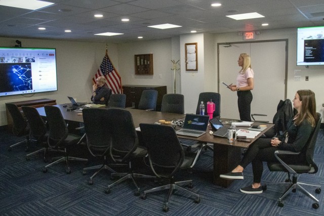 Mentorship program targets next generation talent for next generation challenges/The ASPIRE Program Manager, stands in the center of a conference room during the virtual capstone session.