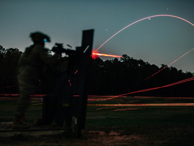 A Paratrooper assigned to 1st Battalion, 505th Parachute Infantry Regiment, 3rd Brigade Combat Team, 82nd Airborne Division, fires his M249 light machine gun at a night qualification range during the 1st Sgt. Funk Deployment Readiness Exercise at...