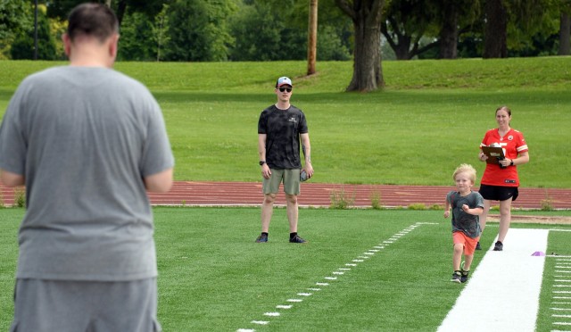 Staff Sgt. Noah Mock, Headquarters and Headquarters Company, Army Corrections Command, watches his 4-year-old son Harbor sprint between judges Sgt. 1st Class David Gonzalez, senior career counselor for ACC, and 1st Lt. Shyla Taylor, HHC, Army...