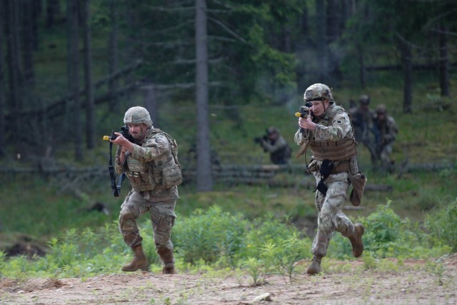 U.S. Army Spc. Jade Hozak-Valdez, (left), and Spc. Anthony Broesma, assigned to Charlie Company, 1st Battalion, 125th Infantry Regiment, Michigan Army National Guard, run towards the trenches during Exercise Baltic Viking near Alūksne, Latvia,...