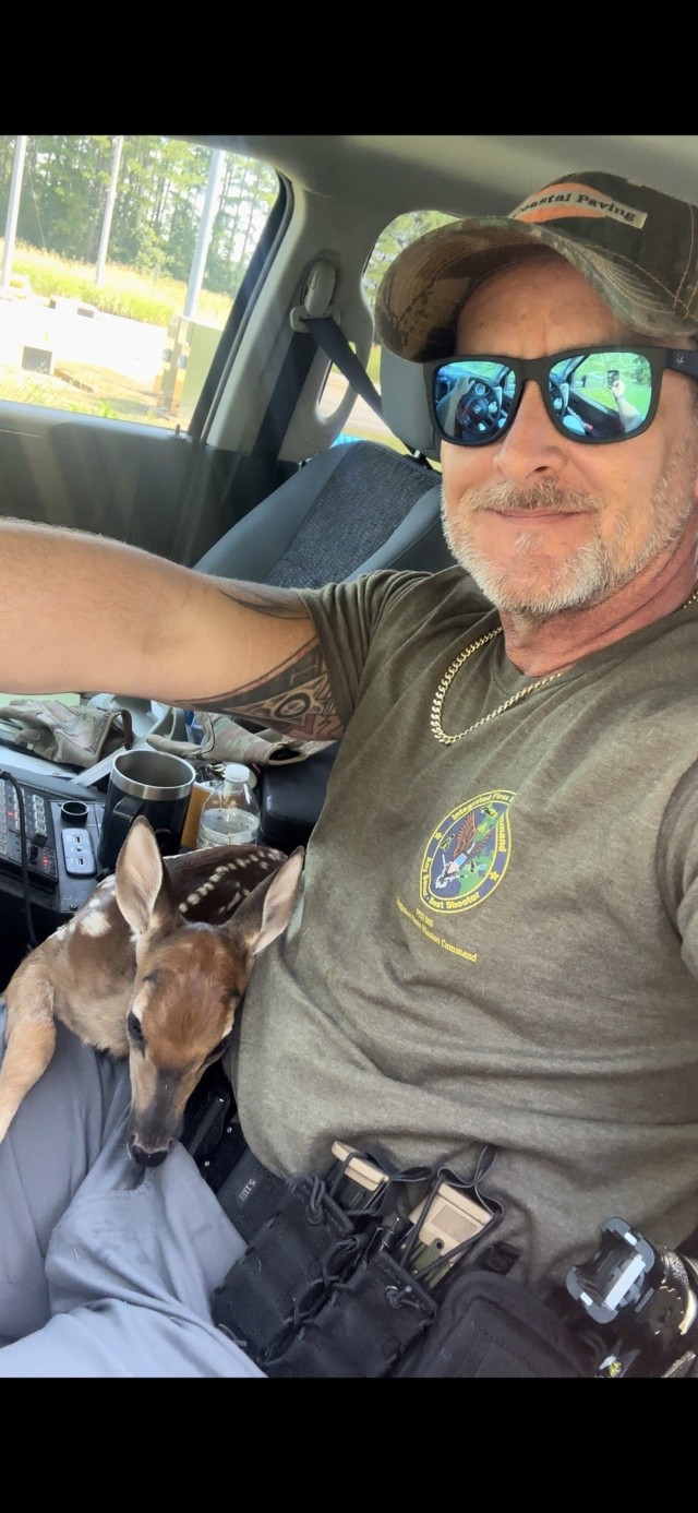 Conservation Law Enforcement Officer Lt. Aaron Hanson with a fawn he rescued in 2024.