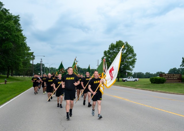 Col. Charles Green, U.S. Army Military Police School commandant (front left), and Col. John Copeland, 14th MP Brigade commander (holding Army flag), lead MP Soldiers away from the Maneuver Support Center of Excellence Plaza down 1st Street, June...