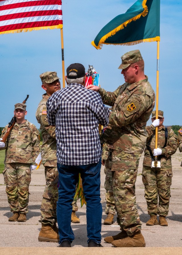 Korean War veteran, Gus Adams of Plato, Missouri, places a Korean War streamer on the U.S. Army flag during a ceremony June 11 on Gammon Field, with assistance from Maj. Gen. Christopher Beck, Maneuver Support center of Excellence and Fort Leonard...
