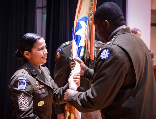 Command Sgt. Maj. Melanie Coronado passes the unit&#39;s colors to the 93d Theater Signal Brigade&#39;s incoming commander, Col. Glenroy Haskins.