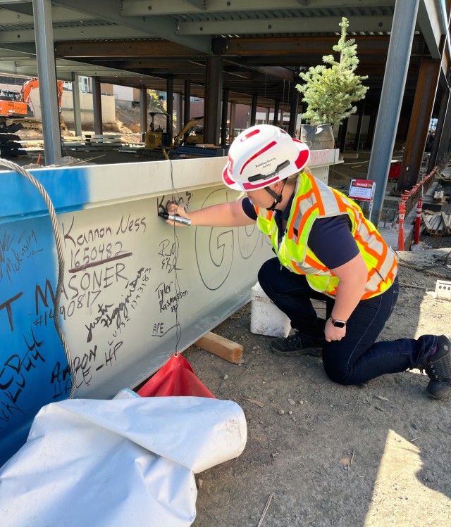 Katlyn Struxness, USACE Seattle District project engineer, signs a structural beam to celebrate the completion of the Plant Sciences Building main structure in the fall of 2024.