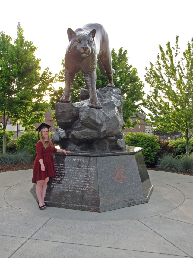 Washington State University alumna Katlyn Struxness stands next to the iconic cougar statue.