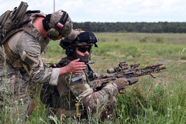 U.S. Army Staff Sgt. Bruno Rios, a cavalry scout with C Troop, 2nd Battalion, 106th Cavalry Regiment, Illinois Army National Guard, confirms that the weapon of his Polish counterpart is clear of ammunition following the completion of a shooting...