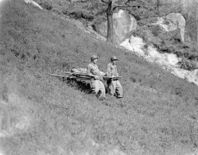 Soldiers practice a medical evacuation by litter, April 1945. (NARA photo)