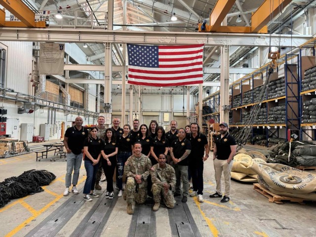 AVIANO AIR BASE, Italy – AMICI participants pose with riggers from the Kilo Company, Brigade Support Battalion, 173rd Airborne Brigade following a tour of the facility. The visit gave garrison employees an up-close look at the precision and...