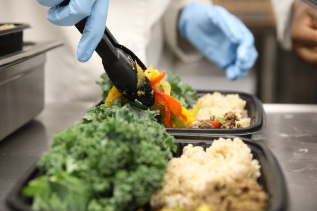 Pfc. Erica Kenmegne, a 92G culinary specialist with 2nd Battalion, 87th Infantry Regiment, 2nd Brigade Combat Team, 10th Mountain Division (LI), adds the final touch to a Meal Prep to-go meal at the Commando Warrior Restaurant at Fort Drum. The...
