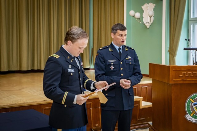 Maj. Scott Ratzer, 10th Special Forces Group (Airborne), receives the award for best classmate from class leader Maj. Andrius Kabašinskas.