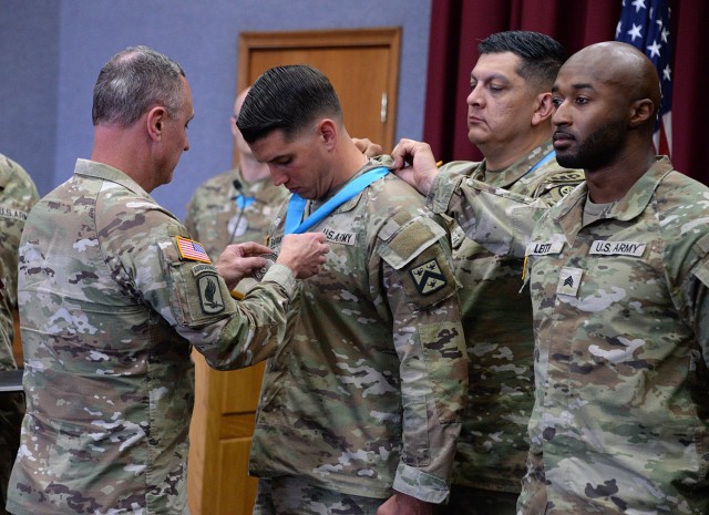 Combined Arms Center and Fort Leavenworth Command Sgt. Maj. Shawn Carns and Sergeant Audie Murphy Club Lamp Chapter President 1st Sgt. Martin Alonzo present the SAMC medallion to Sgt. 1st Class Cody Barratt, before doing the same for fellow SAMC...
