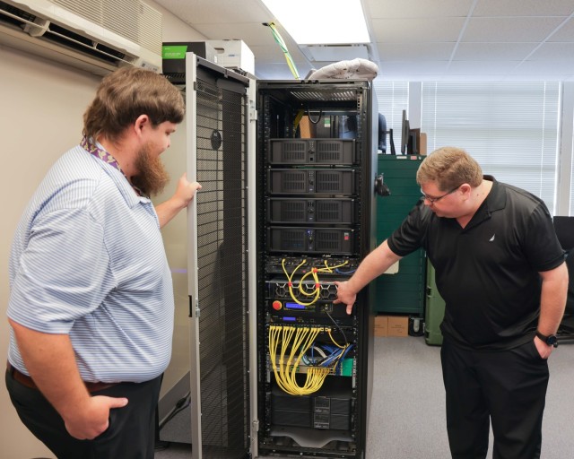 DEVCOM AvMC's William Vance, left, and John Ross demonstrate the technology they built to test the airworthiness of multi-core processors.