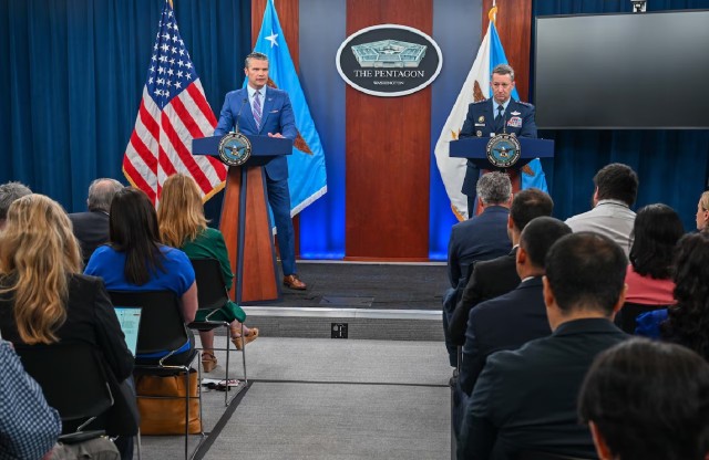 Leaders on podium in front of crowd of interviewers and journalists