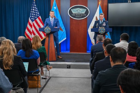 Leaders on podium in front of crowd of interviewers and journalists