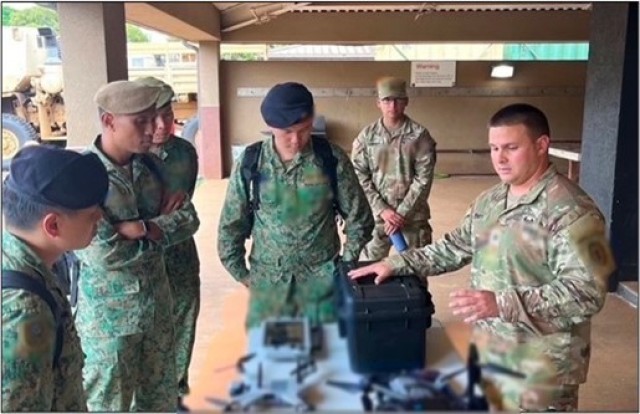 Members of the Singapore Armed Forces delegation receive a brief on unmanned aerial system capabilities.