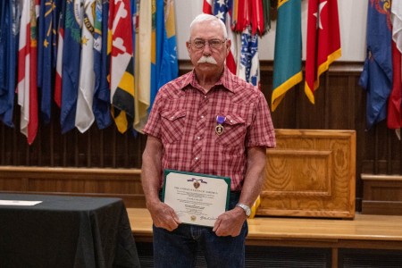 Nelson Allen poses with his Purple Heart Medal June 27 in Lincoln Hall Auditorium.