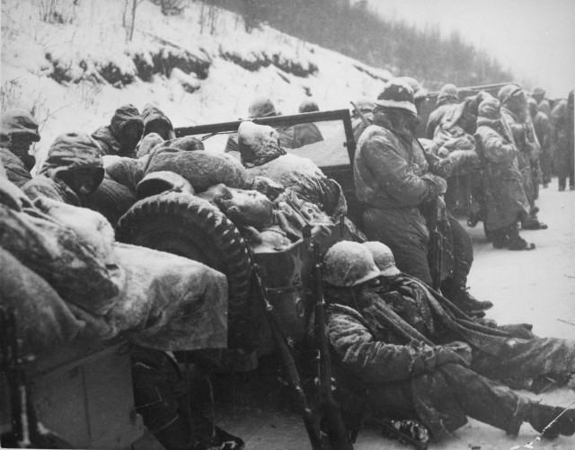 Marines of the 5th and 7th Regiments, who hurled back a surprise onslaught by three Chinese communist divisions, wait to withdraw following the Battle of Chosin Reservoir.