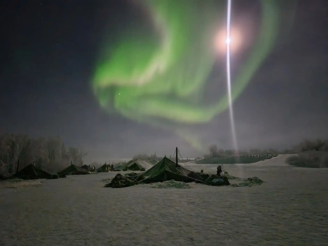 11th Airborne Division Soldiers utilize 10-man ahkio groups under the Northern Lights during a recent exercise.