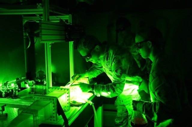 Cadets conduct adjustments on their laser imaging experiment to study contaminant dispersion flow.