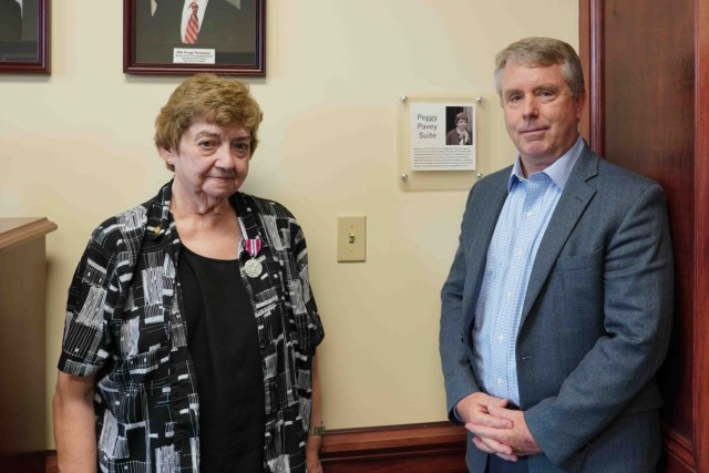 Mary Pavey, left, poses with Gregg Thompson, deputy to the commanding general, right, during the unveiling of the Peggy Paven Suite June 30, 2025. Pavey retired July 1, 2025, after 56 years of federal service and her old office was officially...