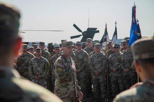 U.S. Soldiers assigned to 12th Combat Aviation Brigade gather as outgoing brigade commander Col. Ryan Kendall delivers final remarks during 12 CAB's change of command ceremony on Katterbach Army Airfield, Ansbach, Germany, July 2, 2025. Kendall...