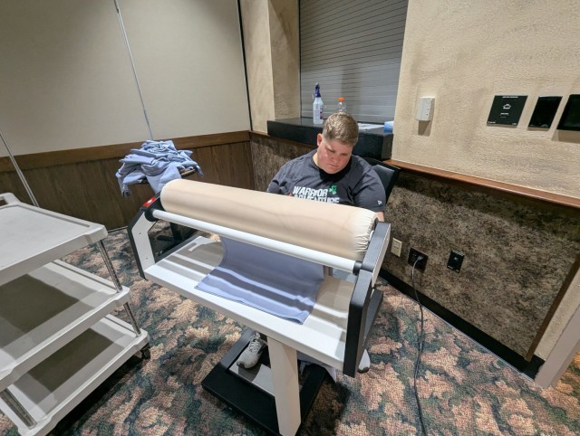 Brittany Garnsey, Fort Drum FMWR Business and Recreation Division coordinator at The Peak, presses linen tablecloths for an upcoming event during Mountainfest Week. For a typical ballroom event, they would press 30 to 40 tablecloths, which can be...
